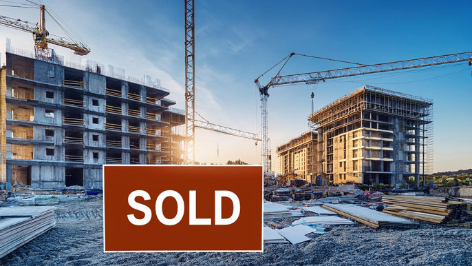 A construction site with partially built buildings and a large "Sold" sign in the foreground, symbolizing the concept of off-plan property developments, where investors purchase properties before they are completed.