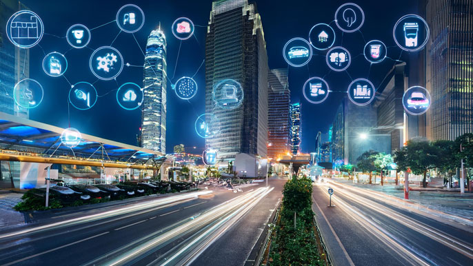 Smart city street at night with IoT icons representing data connectivity