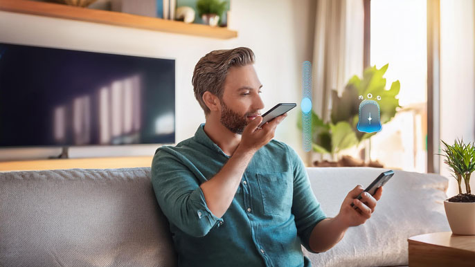 A man on a couch using voice search on his smartphone, with a voice assistant icon visible.