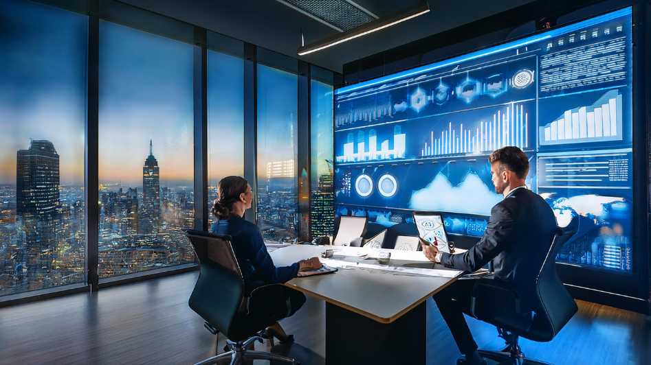 Business professionals in a modern office analyzing data and research reports displayed on large screens, discussing strategies for business success based on research insights and data-driven decision-making.