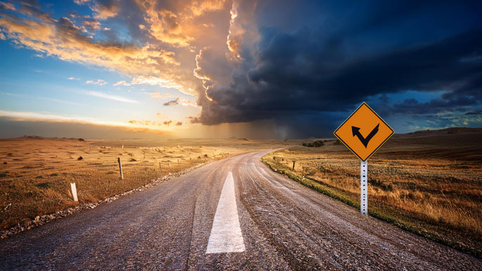 A road with a bright sky ahead after a storm, symbolizing recovery and resilience in business, with a road sign pointing toward a positive path forward.